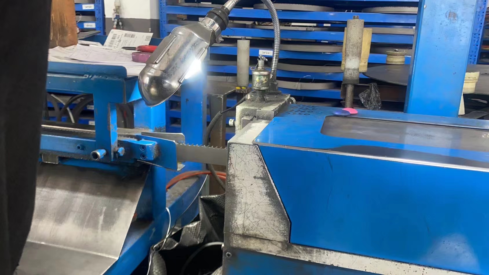 Band Saw Machine Maintenance A maintenance worker inspecting the guide blocks of a band saw machine