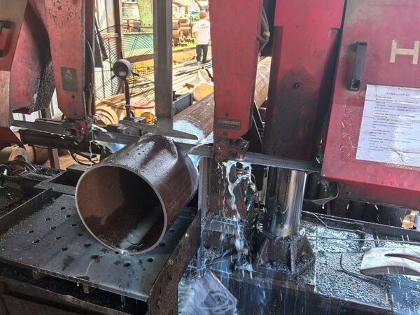 increase band saw blade life a close-up of a band saw blade cutting through a metal block